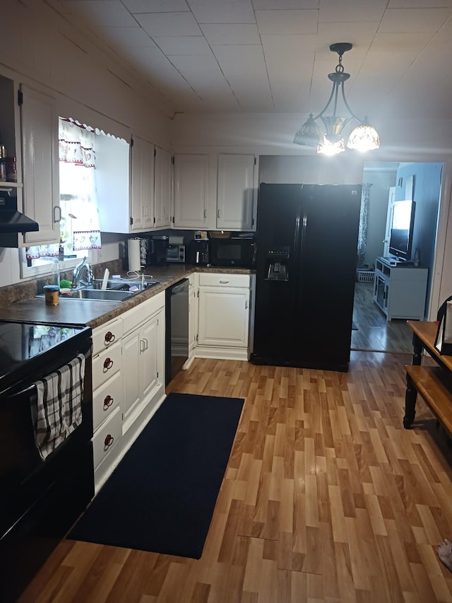 197 Stigall St, Camden, TN 38320 - kitchen featuring black appliances, white cabinets, light wood-style flooring, and a chandelier