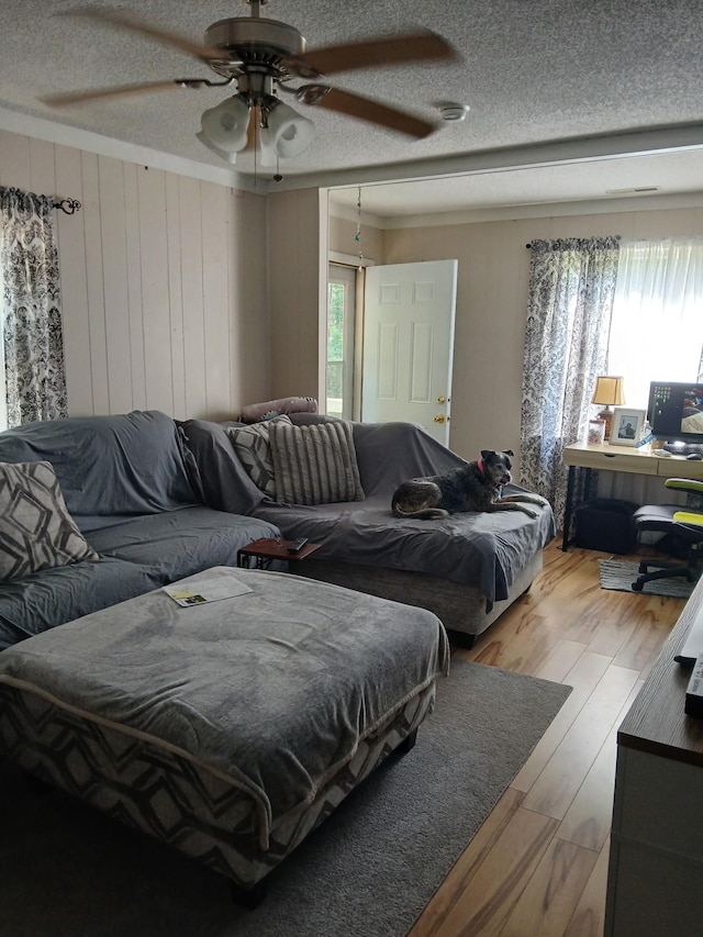 197 Stigall St, Camden, TN 38320 - living area featuring ceiling fan, wood finished floors, wooden walls, and a textured ceiling