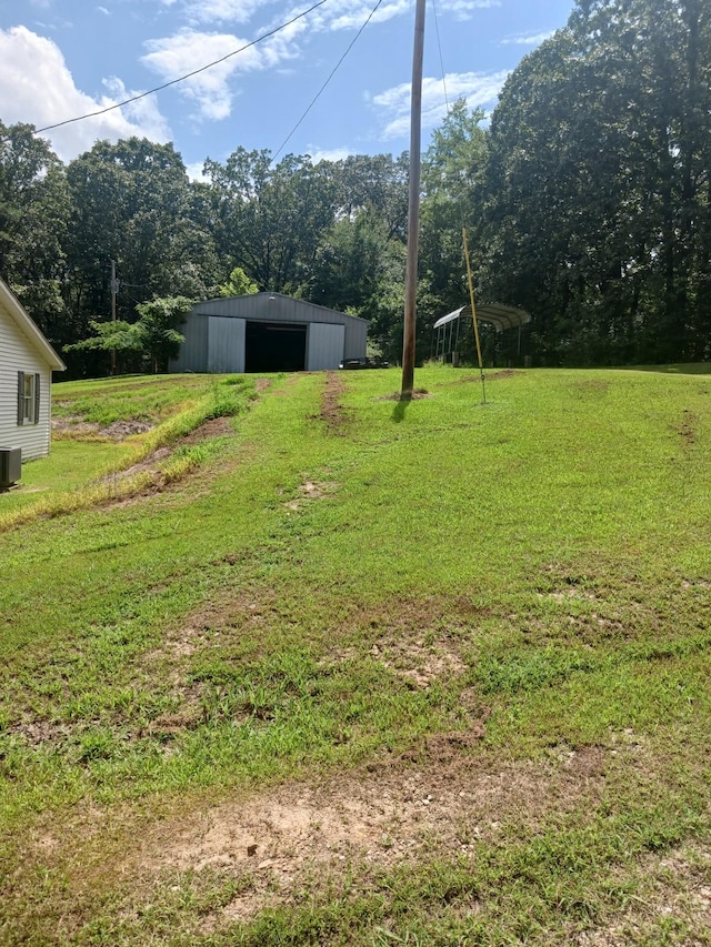 197 Stigall St, Camden, TN 38320 - view of grassy yard with an outbuilding, an outdoor structure, and a detached garage
