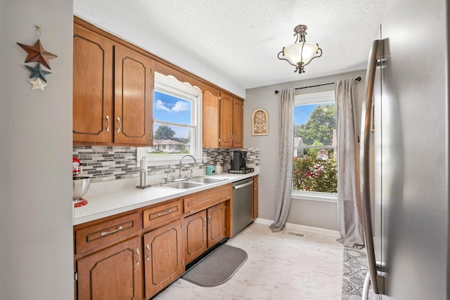561 Danielle Dr, Clarksville, TN 37042 - kitchen featuring dishwasher, decorative backsplash, light countertops, brown cabinets, and a textured ceiling
