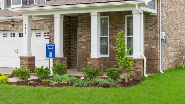 3412 Shigo St, Murfreesboro, TN 37130 - view of exterior entry with brick siding, roof with shingles, a yard, and an attached garage