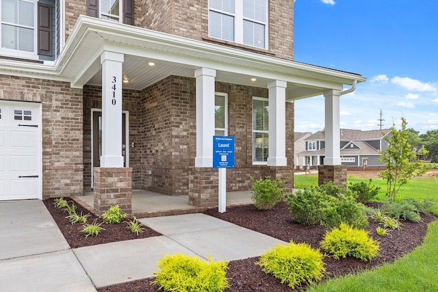 3412 Shigo St, Murfreesboro, TN 37130 - property entrance featuring covered porch, a garage, and brick siding