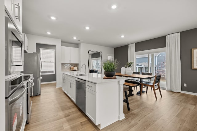 3412 Shigo St, Murfreesboro, TN 37130 - kitchen featuring a breakfast bar area, appliances with stainless steel finishes, light countertops, light wood-type flooring, and a kitchen island with sink
