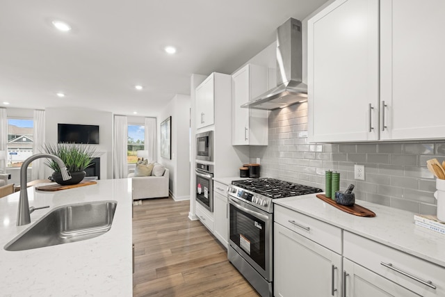 3412 Shigo St, Murfreesboro, TN 37130 - kitchen featuring open floor plan, appliances with stainless steel finishes, wall chimney exhaust hood, white cabinets, and recessed lighting