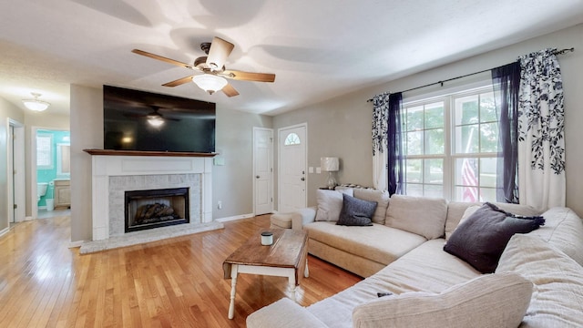 1006 Summer Ln, Pleasant View, TN 37146 - living room featuring light wood finished floors, a ceiling fan, and a fireplace with raised hearth