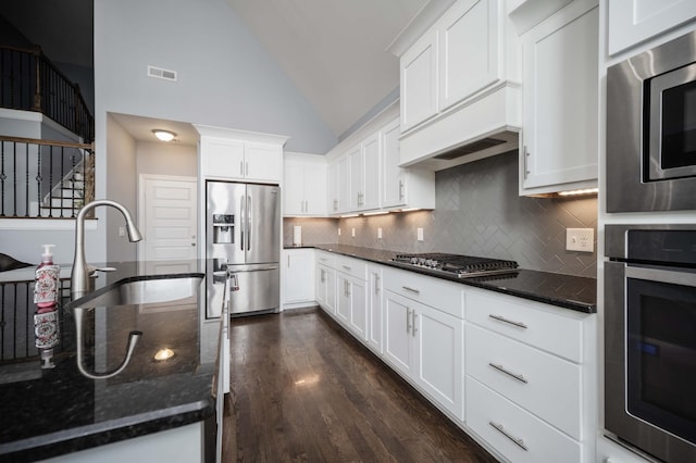 2331 Lionheart Dr, Murfreesboro, TN 37130 - kitchen with appliances with stainless steel finishes, decorative backsplash, white cabinets, dark stone countertops, and dark wood-style flooring