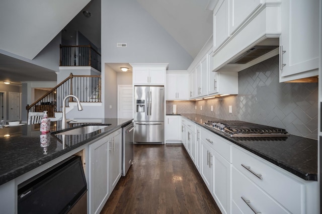 2331 Lionheart Dr, Murfreesboro, TN 37130 - kitchen with appliances with stainless steel finishes, high vaulted ceiling, white cabinets, dark stone countertops, and backsplash