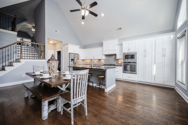 2331 Lionheart Dr, Murfreesboro, TN 37130 - dining area with ceiling fan, high vaulted ceiling, stairs, and dark wood finished floors