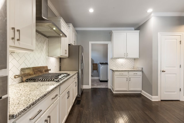7156 Triple Crown Ln, Fairview, TN 37062 - kitchen featuring wall chimney exhaust hood, appliances with stainless steel finishes, backsplash, washer / dryer, and light stone countertops
