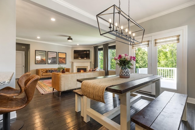 7156 Triple Crown Ln, Fairview, TN 37062 - dining space with crown molding, a lit fireplace, recessed lighting, dark wood-style floors, and a chandelier
