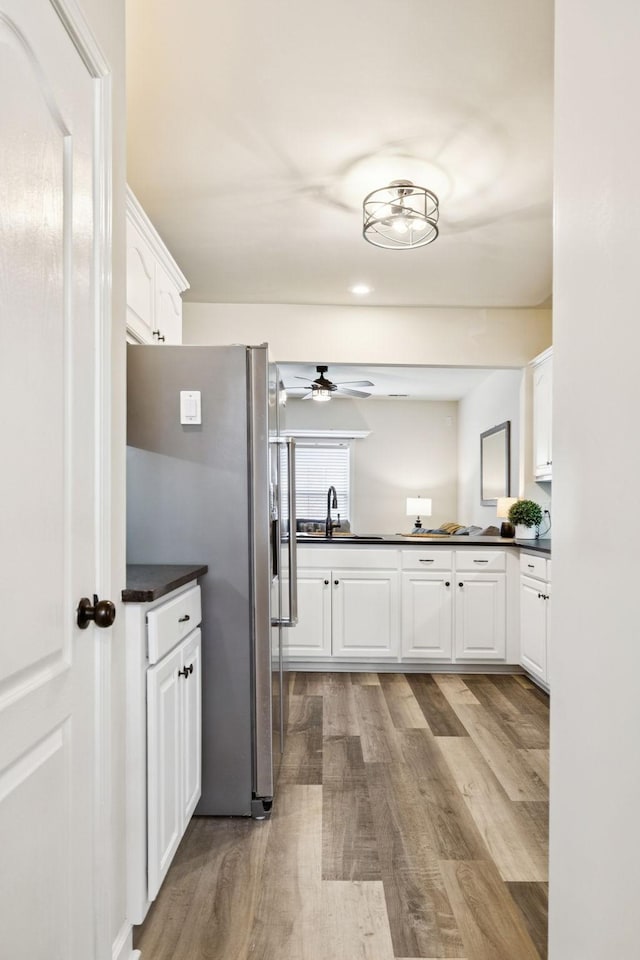 2414 Keegan Dr, Murfreesboro, TN 37130 - kitchen featuring stainless steel refrigerator with ice dispenser, dark countertops, light wood-type flooring, and white cabinetry