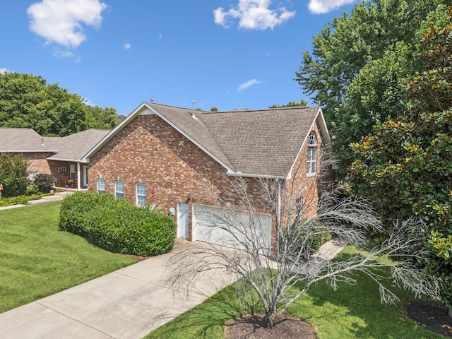 2414 Keegan Dr, Murfreesboro, TN 37130 - view of side of home featuring brick siding, roof with shingles, concrete driveway, a lawn, and a garage