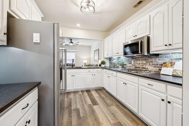 2414 Keegan Dr, Murfreesboro, TN 37130 - kitchen with stainless steel appliances, dark countertops, ceiling fan, light wood-style flooring, and white cabinets