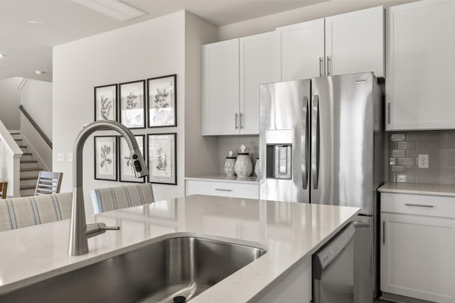 1243 Tucker Dr, Lebanon, TN 37087 - kitchen with light stone counters, tasteful backsplash, white cabinets, and appliances with stainless steel finishes