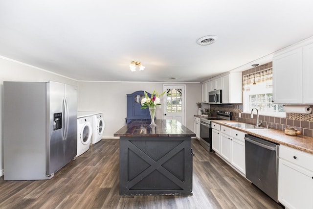 5519 Noble King Rd, Franklin, TN 37064 - kitchen with stainless steel appliances, washer and dryer, a kitchen island, decorative backsplash, and white cabinets