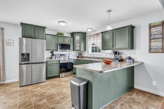 1338 Loren Cir, Clarksville, TN 37042 - kitchen featuring stainless steel appliances, green cabinetry, a peninsula, hanging light fixtures, and light countertops