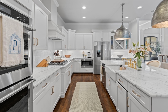 7318 Harlow Dr, College Grove, TN 37046 - kitchen with appliances with stainless steel finishes, white cabinets, a kitchen island, recessed lighting, and hanging light fixtures