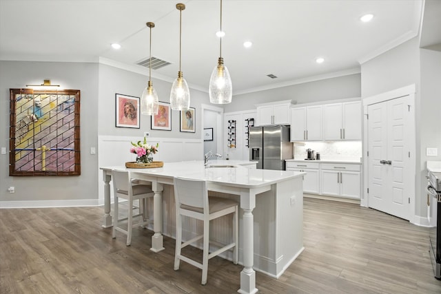 2135 Halfmoon Way, Murfreesboro, TN 37130 - kitchen with stainless steel fridge with ice dispenser, crown molding, light wood-type flooring, light countertops, and a center island with sink