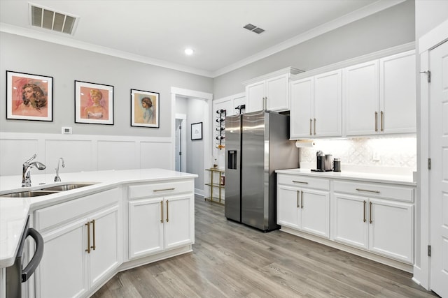 2135 Halfmoon Way, Murfreesboro, TN 37130 - kitchen with appliances with stainless steel finishes, crown molding, light countertops, white cabinetry, and decorative backsplash