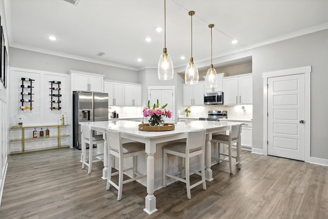 2135 Halfmoon Way, Murfreesboro, TN 37130 - kitchen with appliances with stainless steel finishes, crown molding, decorative backsplash, white cabinets, and a large island with sink
