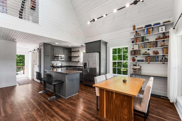 1418 Ridge Rd, Dickson, TN 37055 - kitchen featuring open shelves, stainless steel appliances, a breakfast bar area, a center island, and a towering ceiling