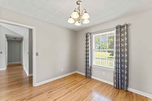 232 Elmwood Dr, Murfreesboro, TN 37128 - empty room featuring a chandelier, light wood-type flooring, and a textured ceiling