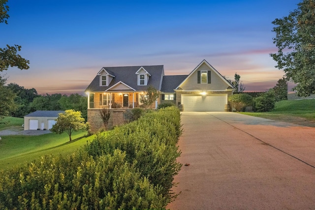 268 Crest Dr, Lynchburg, TN 37352 - new england style home with concrete driveway, a porch, a front yard, and stone siding
