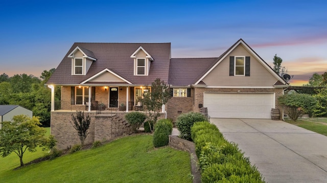 268 Crest Dr, Lynchburg, TN 37352 - view of front facade featuring a front yard, concrete driveway, brick siding, a garage, and a porch