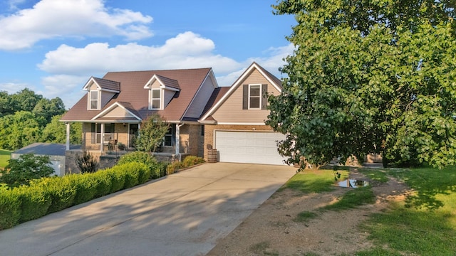 268 Crest Dr, Lynchburg, TN 37352 - view of front of house with brick siding, a porch, concrete driveway, and an attached garage