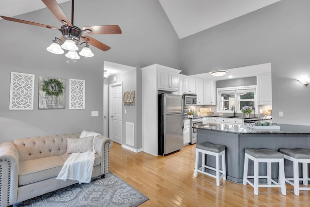 268 Crest Dr, Lynchburg, TN 37352 - kitchen with appliances with stainless steel finishes, high vaulted ceiling, a kitchen breakfast bar, ceiling fan, and white cabinetry
