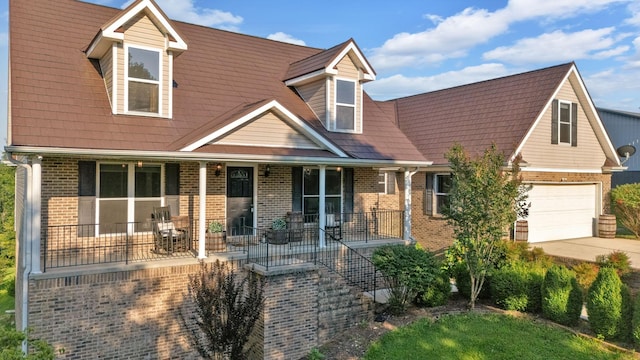 268 Crest Dr, Lynchburg, TN 37352 - view of front facade with a porch, brick siding, driveway, and a garage