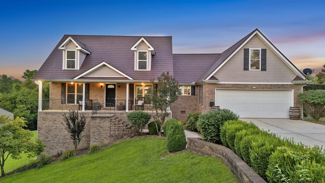 268 Crest Dr, Lynchburg, TN 37352 - view of front of property with brick siding, driveway, a garage, a front lawn, and a porch