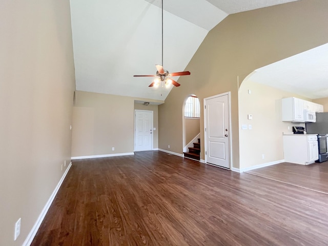 2763 Ridgepole Dr, Clarksville, TN 37040 - unfurnished living room featuring ceiling fan, arched walkways, dark wood-type flooring, stairway, and high vaulted ceiling