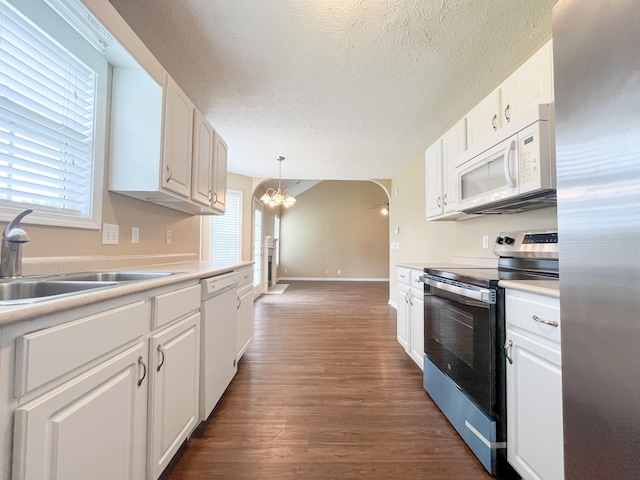 2763 Ridgepole Dr, Clarksville, TN 37040 - kitchen featuring stainless steel appliances, a chandelier, a textured ceiling, white cabinetry, and dark wood finished floors