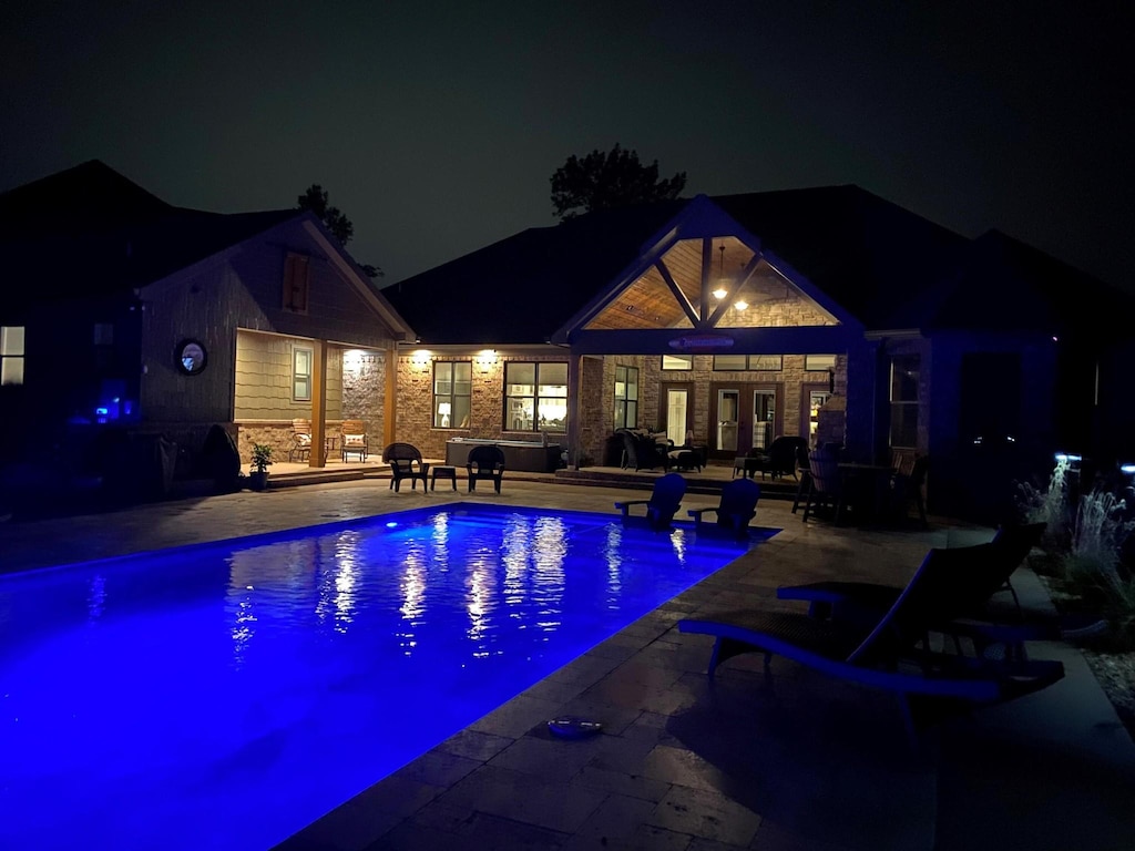 9047 Sunridge Dr, Ooltewah, TN 37363 - pool at twilight featuring a patio area, an outdoor pool, and french doors