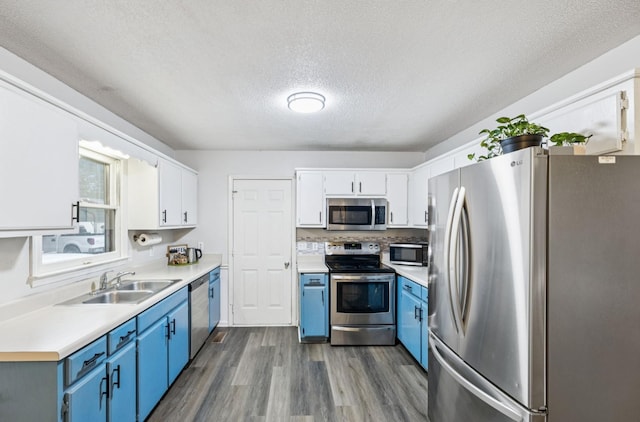4651 Cynthia Ln, Murfreesboro, TN 37127 - kitchen featuring stainless steel appliances, blue cabinets, dark wood-type flooring, light countertops, and a textured ceiling