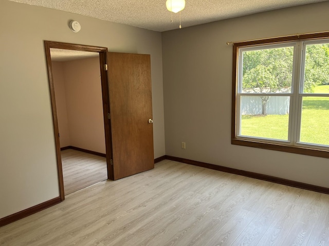 538 Lincoln St, Pulaski, TN 38478 - unfurnished bedroom with light wood finished floors, a textured ceiling, and multiple windows