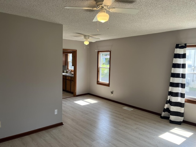 538 Lincoln St, Pulaski, TN 38478 - unfurnished room with light wood-style floors, healthy amount of natural light, a ceiling fan, and a textured ceiling