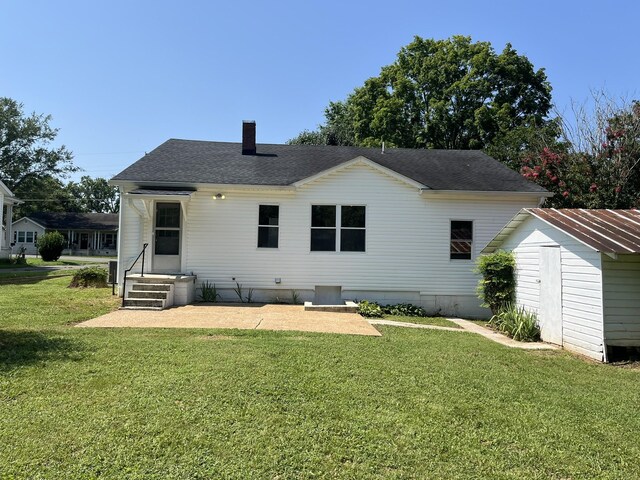 538 Lincoln St, Pulaski, TN 38478 - back of property with a yard, a chimney, a storage shed, a shingled roof, and a patio