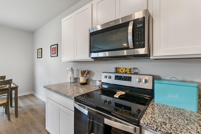 125 Stammer Farms Blvd, Chapel Hill, TN 37034 - kitchen with stainless steel appliances, light wood-style floors, white cabinets, and light stone counters