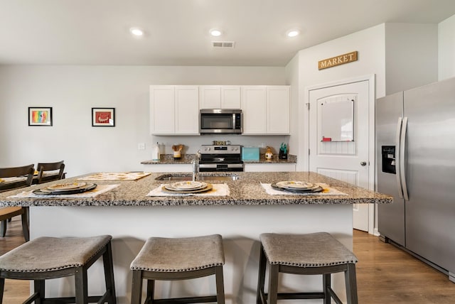 125 Stammer Farms Blvd, Chapel Hill, TN 37034 - kitchen featuring stainless steel appliances, white cabinetry, a kitchen bar, stone countertops, and recessed lighting