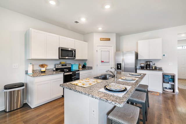125 Stammer Farms Blvd, Chapel Hill, TN 37034 - kitchen with stainless steel appliances, a breakfast bar area, dark wood-type flooring, light stone counters, and recessed lighting