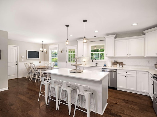 310 Diane Loop, White Bluff, TN 37187 - kitchen with stainless steel dishwasher, white cabinets, tasteful backsplash, a kitchen breakfast bar, and light countertops