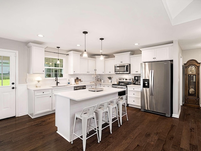 310 Diane Loop, White Bluff, TN 37187 - kitchen with stainless steel appliances, white cabinetry, tasteful backsplash, light countertops, and a breakfast bar area