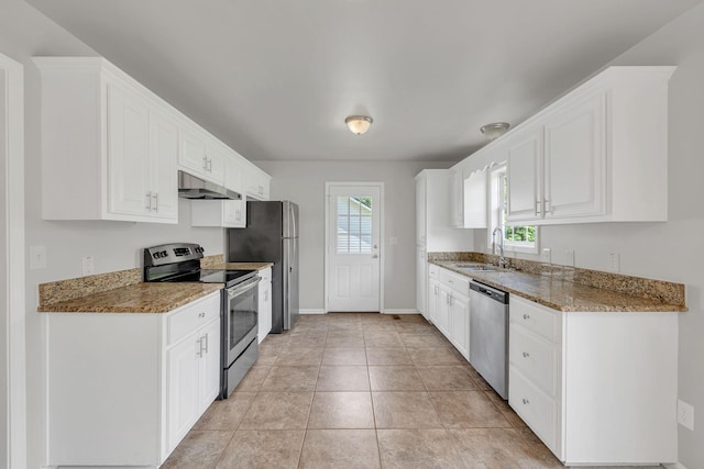 2995 Pipkin Hills Dr, Spring Hill, TN 37174 - kitchen with stainless steel appliances, under cabinet range hood, white cabinetry, light stone counters, and light tile patterned floors