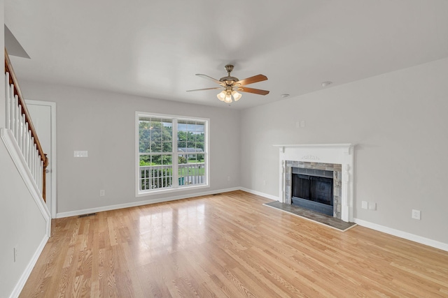 2995 Pipkin Hills Dr, Spring Hill, TN 37174 - unfurnished living room featuring light wood-style floors, ceiling fan, a fireplace, and stairway