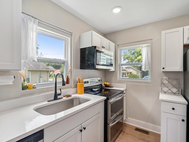2011 Denham Ave, Columbia, TN 38401 - kitchen with appliances with stainless steel finishes, light wood finished floors, white cabinetry, light countertops, and recessed lighting