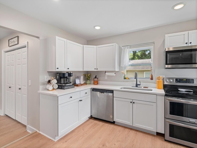2011 Denham Ave, Columbia, TN 38401 - kitchen featuring appliances with stainless steel finishes, light countertops, white cabinetry, light wood-type flooring, and recessed lighting