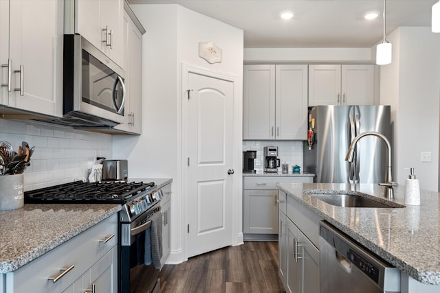 3702 Mathewson Way, Murfreesboro, TN 37128 - kitchen featuring appliances with stainless steel finishes, dark wood-style flooring, gray cabinetry, decorative backsplash, and light stone counters
