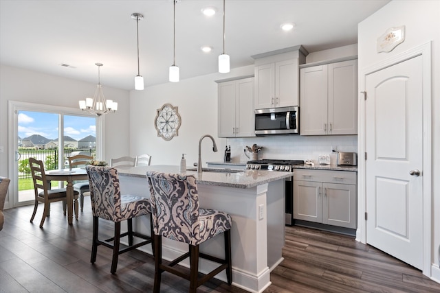 3702 Mathewson Way, Murfreesboro, TN 37128 - kitchen featuring appliances with stainless steel finishes, decorative backsplash, dark wood-style floors, a breakfast bar, and an island with sink